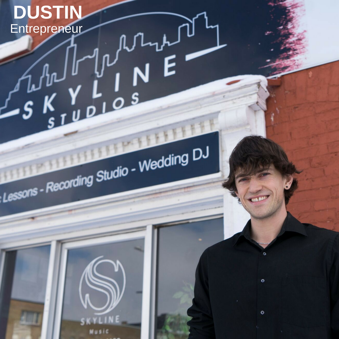 Man smiling outside in front of his music studio