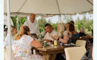 Group of people eating outside under a tent